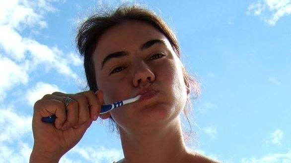 Woman brushing her teeth outdoors