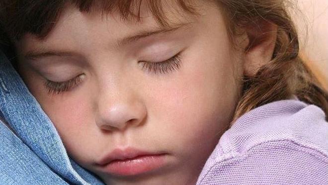 Child sleeping with their head resting on a pillow